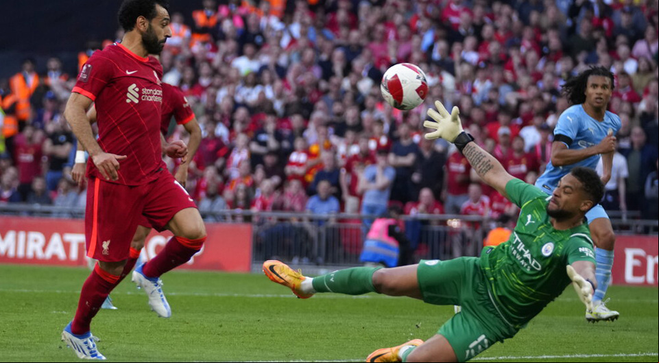 Salah trata de superar a Ederson picando el balón. Pronósticos de la computadora de la Premier League.