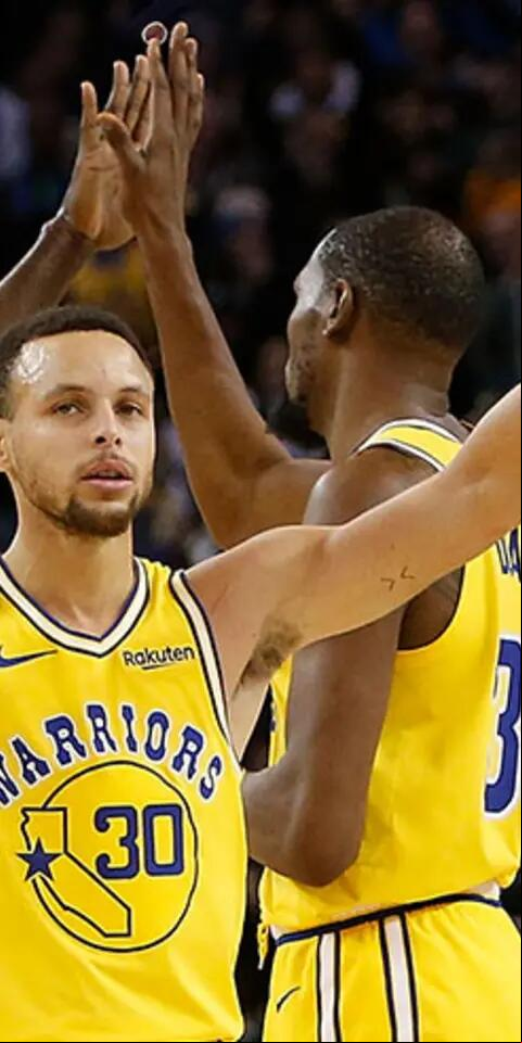 Kevin Durant #35, Stephen Curry #30 and Draymond Green #23 of the Golden State Warriors celebrate after a basket against the Portland Trail Blazers at ORACLE Arena on December 27, 2018 in Oakland, California